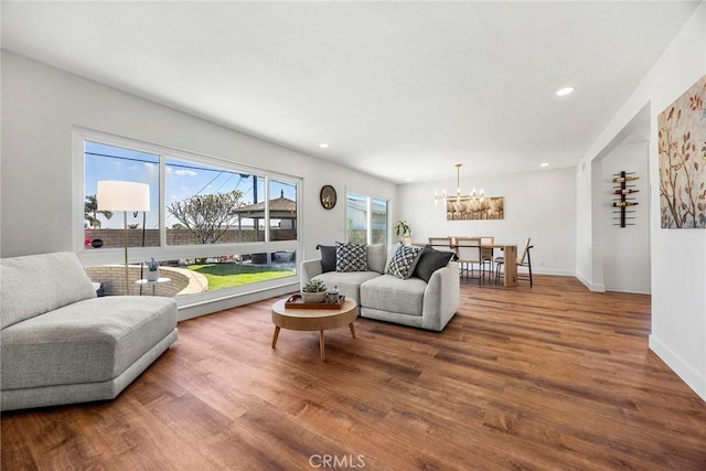 living room featuring baseboards, recessed lighting, wood finished floors, and a chandelier