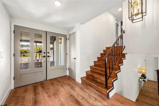 entryway with french doors, wood finished floors, stairway, baseboards, and recessed lighting