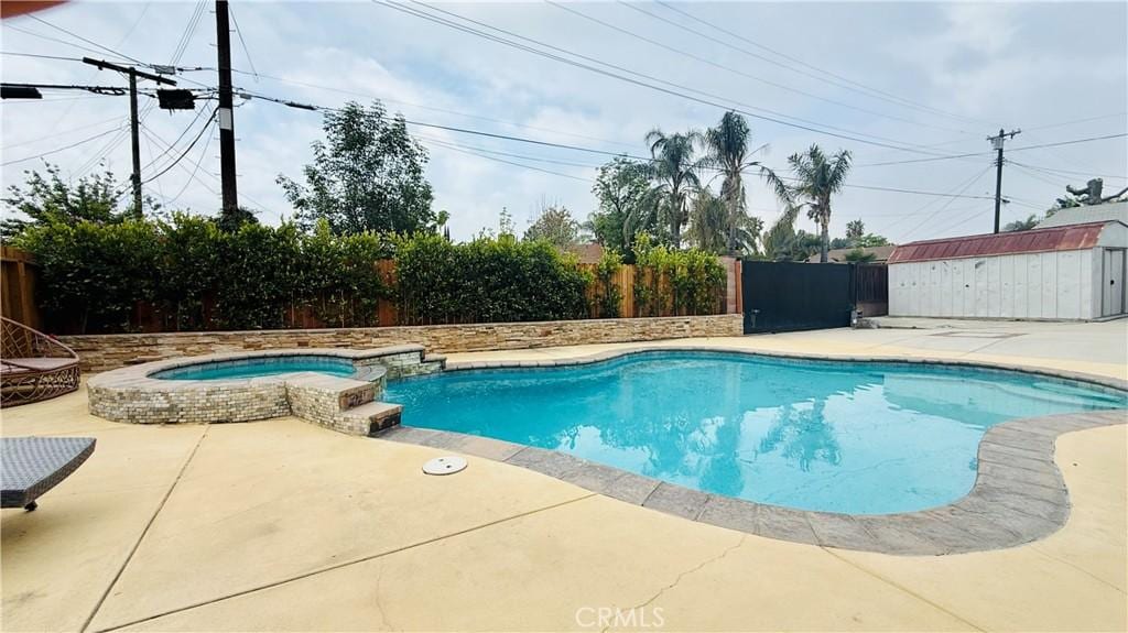 view of swimming pool with a pool with connected hot tub, a patio, and a fenced backyard