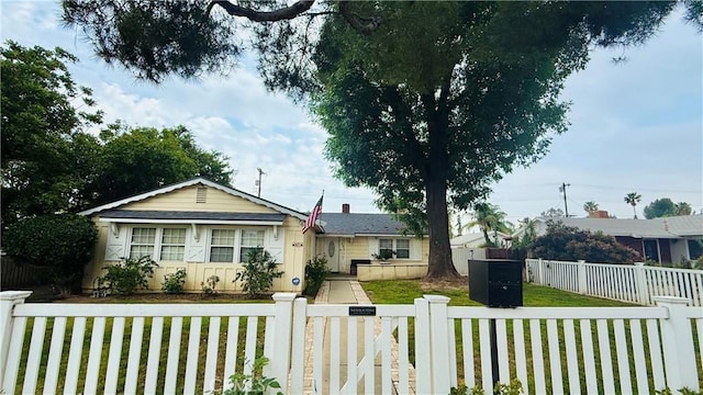bungalow featuring a fenced front yard and a front yard