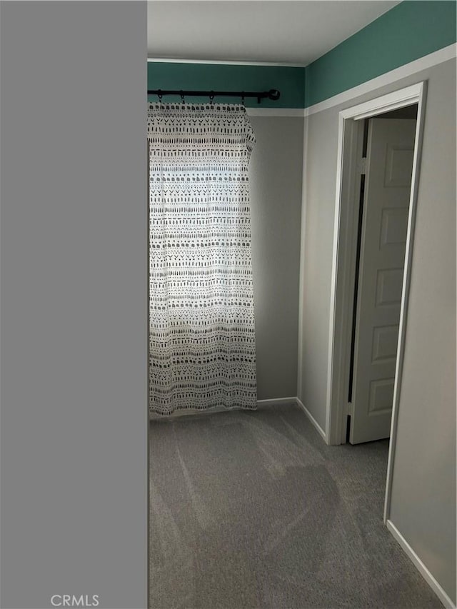 unfurnished room with baseboards and carpet
