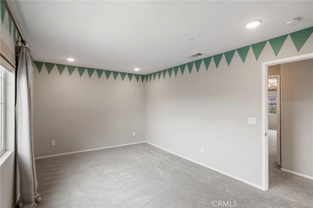 carpeted spare room with recessed lighting, baseboards, and visible vents
