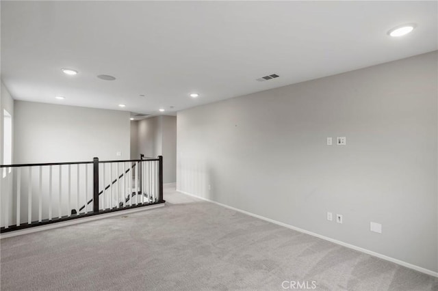 empty room with carpet floors, baseboards, recessed lighting, and visible vents