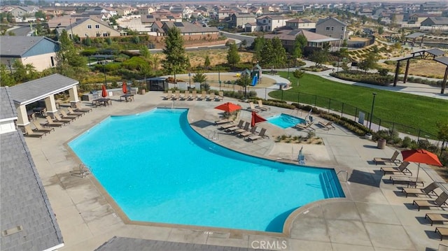 community pool with fence, a yard, and a patio area