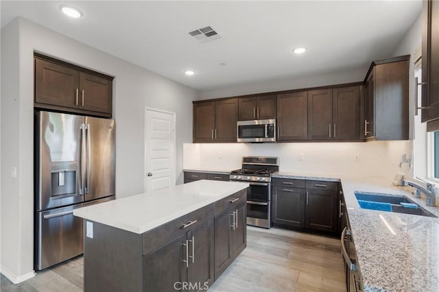 kitchen with visible vents, a sink, dark brown cabinets, and stainless steel appliances