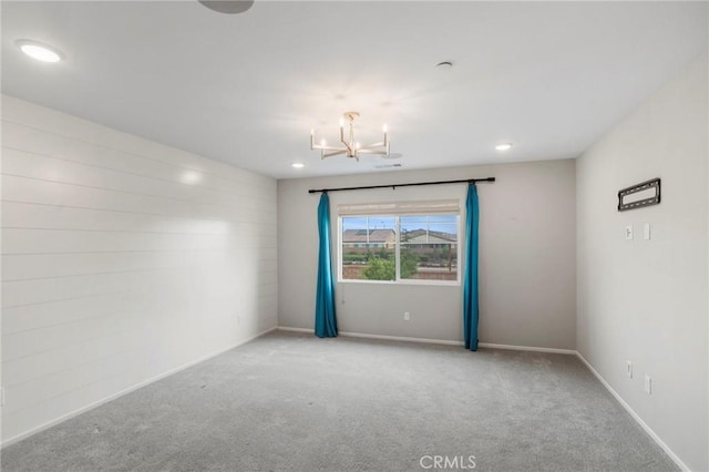 empty room featuring baseboards, carpet flooring, recessed lighting, and a notable chandelier