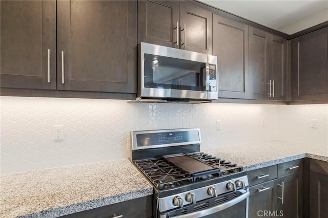 kitchen with tasteful backsplash, dark brown cabinets, and stainless steel appliances