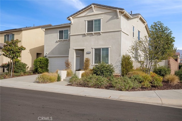 view of front of house with a garage, stucco siding, and concrete driveway