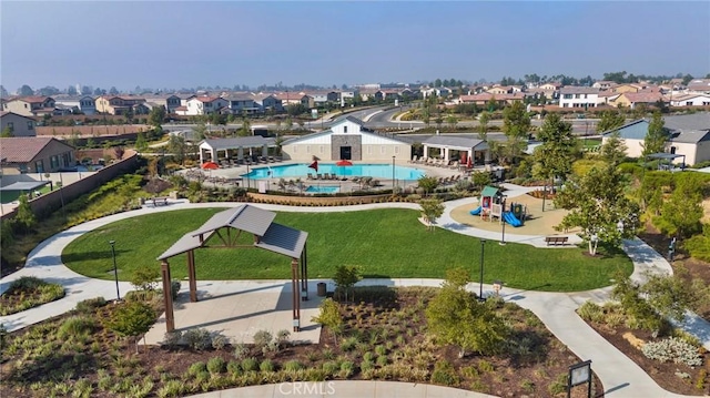view of home's community featuring a residential view, a swimming pool, a lawn, and playground community