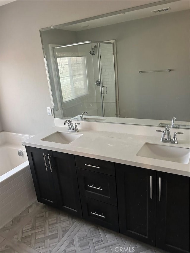 full bathroom with a sink, a shower stall, double vanity, and visible vents