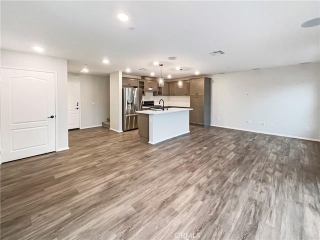 kitchen with visible vents, stainless steel fridge with ice dispenser, open floor plan, recessed lighting, and an island with sink