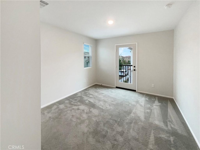 carpeted spare room with baseboards and visible vents