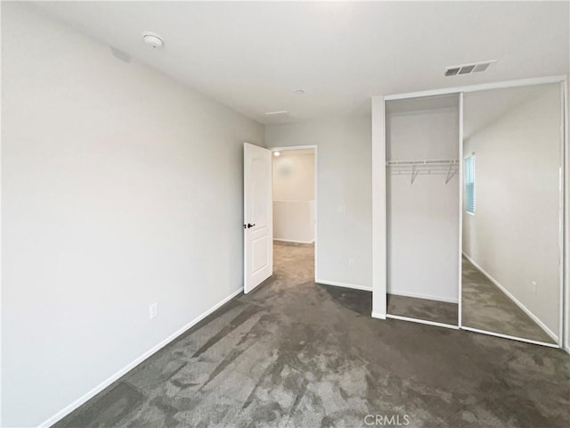 unfurnished bedroom featuring visible vents, carpet flooring, baseboards, and a closet