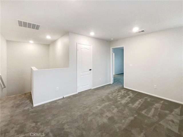 spare room featuring recessed lighting, baseboards, dark colored carpet, and visible vents