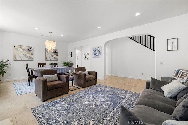 living room featuring arched walkways, light tile patterned floors, recessed lighting, a chandelier, and baseboards