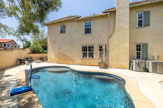 view of swimming pool with a patio area, fence, and central air condition unit