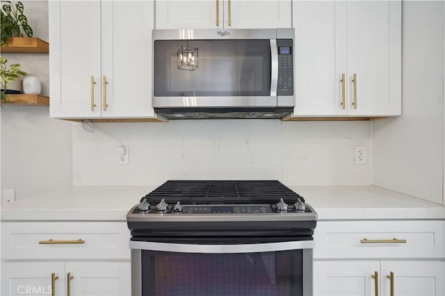 kitchen with light countertops, open shelves, tasteful backsplash, and stainless steel appliances
