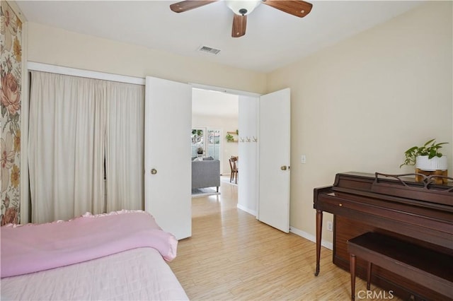 bedroom with visible vents, light wood finished floors, ceiling fan, and baseboards