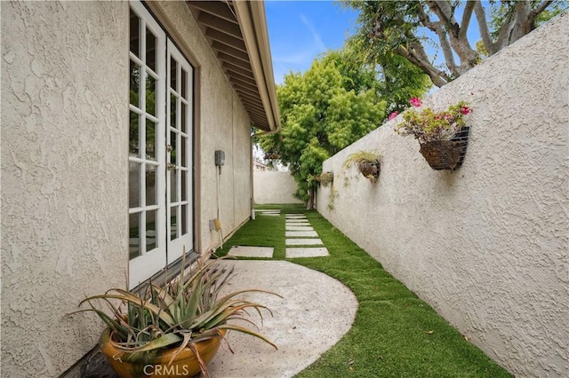 view of yard featuring fence and french doors