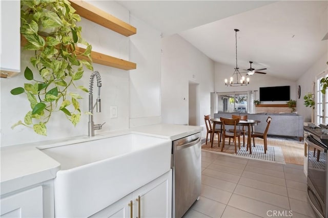 kitchen with white cabinets, a sink, appliances with stainless steel finishes, a notable chandelier, and vaulted ceiling