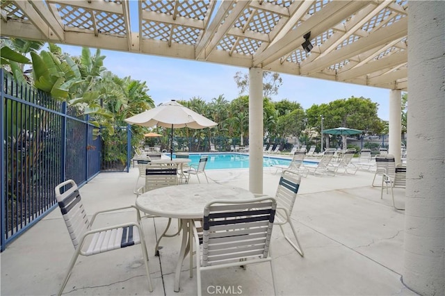view of patio featuring fence, a pergola, and a community pool