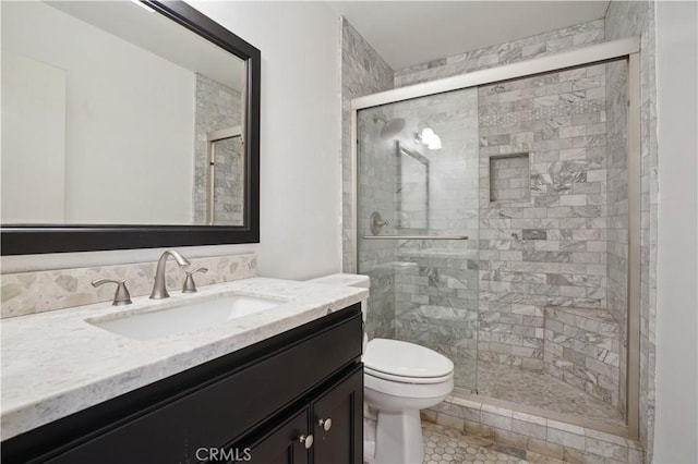 bathroom with vanity, a shower stall, and toilet