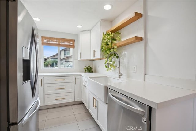 kitchen with stainless steel appliances, open shelves, white cabinetry, and a sink