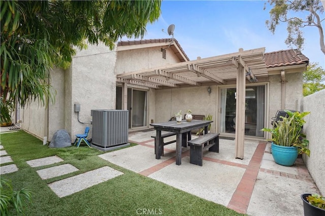 rear view of house featuring a pergola, stucco siding, cooling unit, and a patio