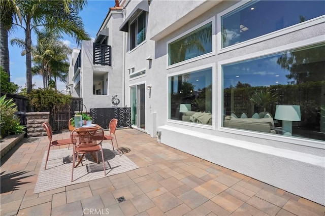 view of patio featuring outdoor dining space and fence