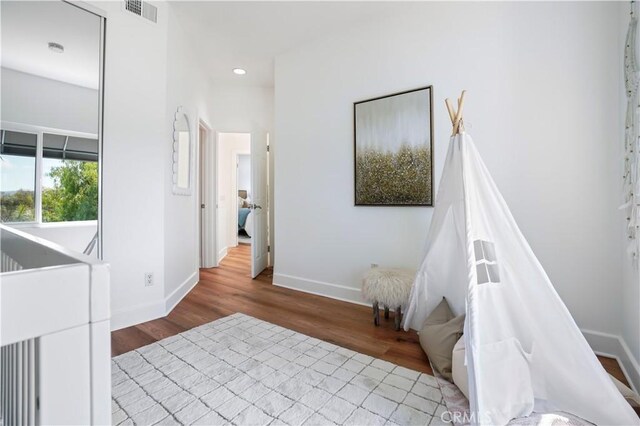 unfurnished bedroom featuring recessed lighting, baseboards, visible vents, and wood finished floors