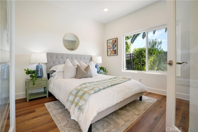 bedroom featuring wood finished floors, baseboards, and recessed lighting