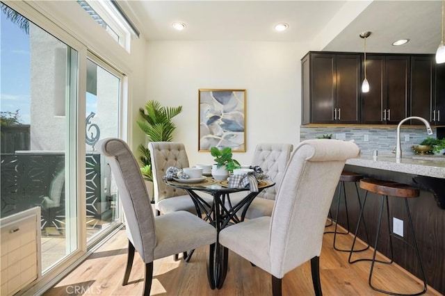 dining space featuring light wood-type flooring and recessed lighting