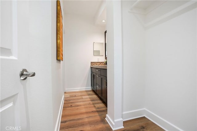 bathroom featuring baseboards, vanity, and wood finished floors