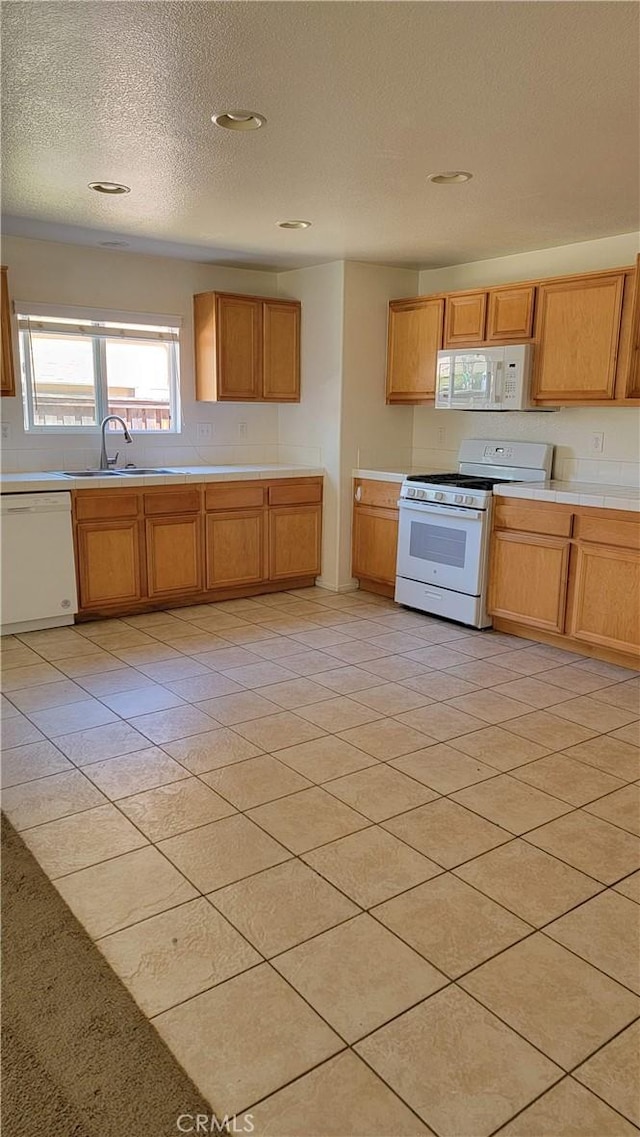 28799 Lavatera Ave, Murrieta, CA 92563 - kitchen with plenty of natural light, a sink, tile counters, and white appliances