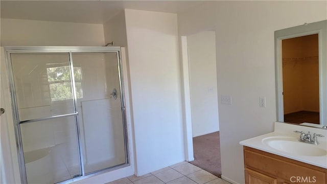28799 Lavatera Ave, Murrieta, CA 92563 - full bathroom featuring tile patterned flooring, vanity, a spacious closet, and a shower stall