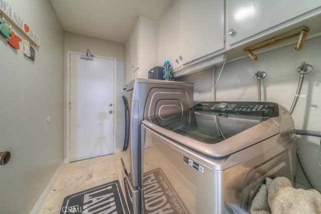 laundry room featuring cabinet space, washer and dryer, and baseboards