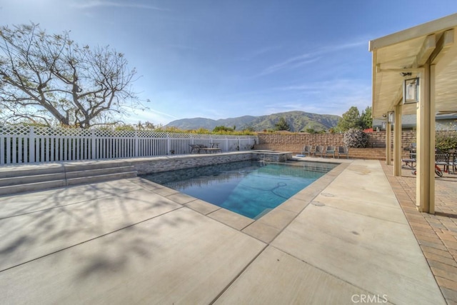 view of swimming pool featuring a fenced backyard, a patio, and a mountain view