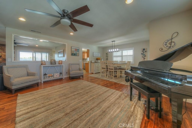 living area featuring ceiling fan, a wealth of natural light, and visible vents