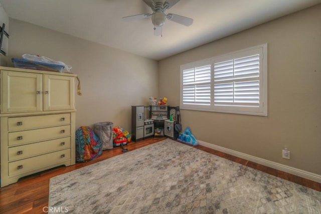 playroom featuring baseboards, wood finished floors, and a ceiling fan