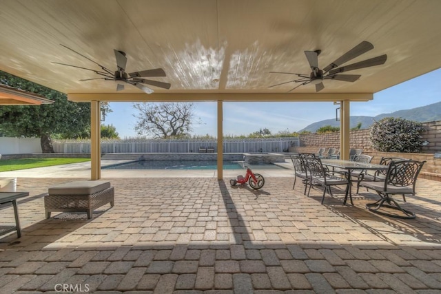 view of patio featuring a fenced backyard, a fenced in pool, a ceiling fan, and outdoor dining area