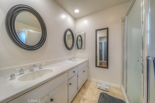 full bathroom featuring a sink, double vanity, an enclosed shower, and baseboards