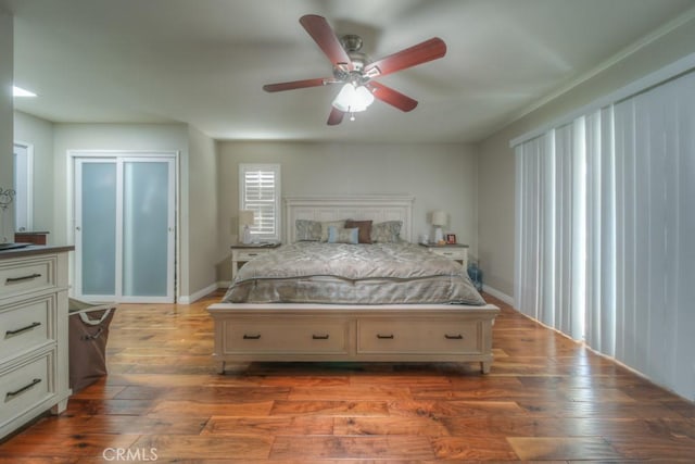 bedroom with baseboards, a ceiling fan, and wood finished floors