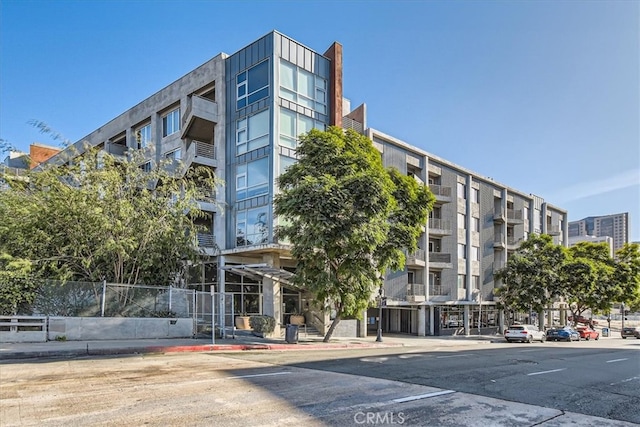 view of property featuring uncovered parking and fence