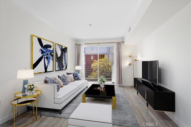 living area with crown molding, baseboards, visible vents, and light wood-type flooring