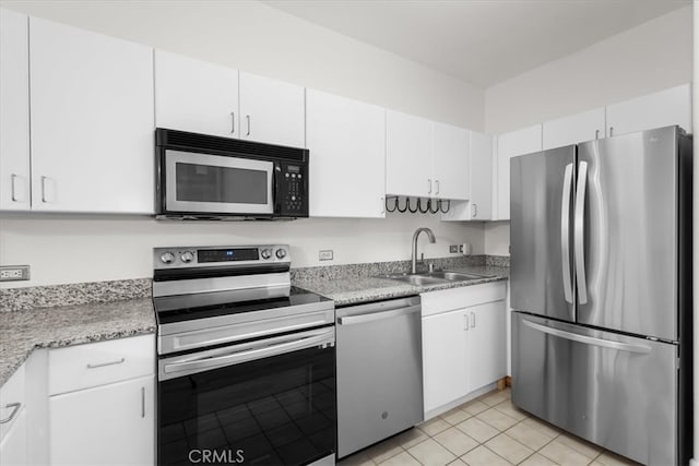 kitchen featuring a sink, appliances with stainless steel finishes, white cabinets, and light tile patterned floors