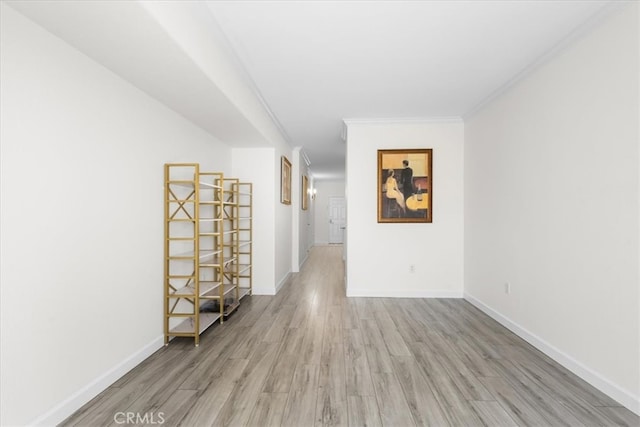 spare room with baseboards, ornamental molding, and wood finished floors
