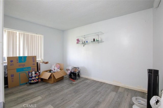 interior space with a textured ceiling and wood finished floors