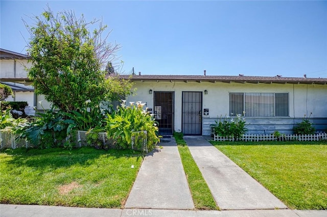 view of front of home featuring stucco siding and a front lawn