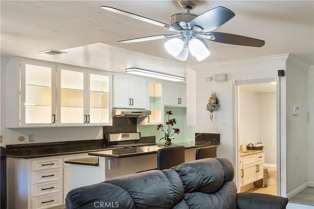 kitchen with ceiling fan, gas stove, white cabinetry, under cabinet range hood, and visible vents