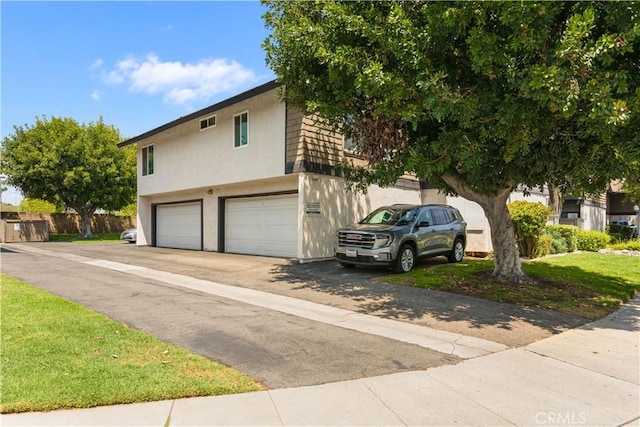 view of front of property featuring an attached garage, stucco siding, and driveway